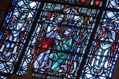 Image of a multi-colored stained glass window with the image of St. Ignatius.